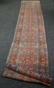 An early twentieth century multi-coloured intricately patterned Persian wool-pile runner carpet,