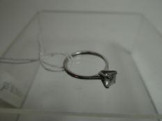 A modern 18ct white gold diamond solitaire ring, the modern round-cut diamond in a four claw