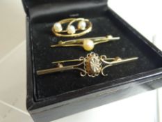 A 9ct and single-pearl bar-brooch, a 9ct three-pearl brooch and another unmarked yellow metal