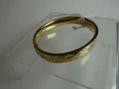 A 9ct yellow gold bright-cut clasp-bangle, 14.2gms