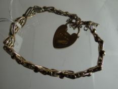 A 9ct yellow gold cross-over gate bracelet with heart-shaped pad-lock, 11.4gms