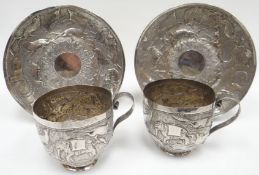 A pair of primitive Indian cups and saucers, decorated with wildlife scenes, 11.4ozs