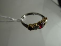 An antique ring set with a row of two brilliant-round cut diamonds interspersed with three rubies in