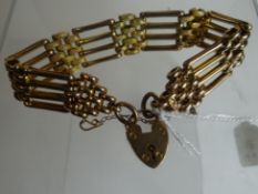 A 9ct yellow gold four-bar gate-bracelet with bright-cut heart-shaped padlock, 17gms
