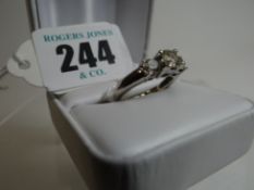 A 14k white gold ring with three stepped diamonds, the centre stone being 0.75ct visual estimate,