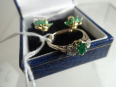 An 18ct white gold ring with earlier yellow gold setting of two diamonds and centre emerald;
