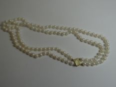 A twin-strand of white pearls with 14k yellow gold clasp, approx 40cms each