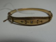 A 9ct yellow gold clasp-bangle with central rope-twist bordered fascia set with single diamond, 7.