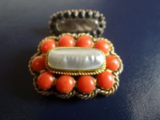 Two antique brooches - a pearl and coral example with believed gold frame and a mourning locket of
