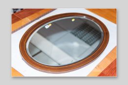 An Edwardian inlaid mahogany oval bevelled edge mirror with boxwood string inlay, 23.5 x 33 ins (