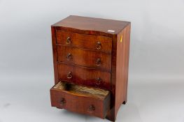 A walnut serpentine fronted apprentice piece chest of drawers, the five drawer fronts with brass