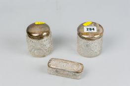 Two hobnail cut glass dressing table jars with silver lids and an oblong glass dressing table box