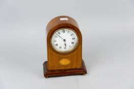 An Edwardian mahogany and boxwood strung mantel clock with Sheraton style fan motif, white enamel