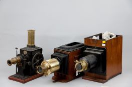 A vintage tinplate and brass Magic Lantern film projector with white pottery winder on wooden base