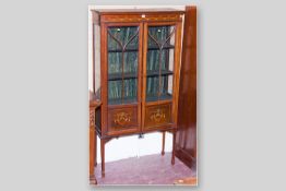 An Edwardian mahogany line inlaid and painted two door china display cabinet on slender supports