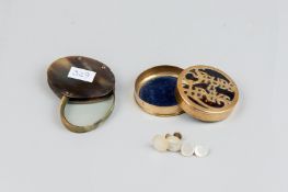 A bone encased oval magnifying glass and a circular brass lidded box, the lid bearing the words '
