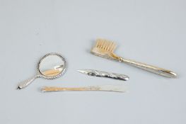 An Art Deco silver gilt moustache brush, Birmingham 1922, a miniature beaten silver hand mirror