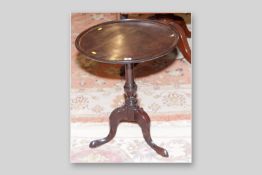 A Georgian mahogany tilt top table, the dished tray top on turned column support and tripod base, 25
