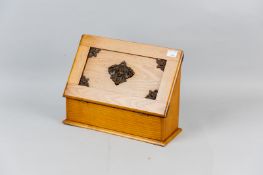 A light oak desktop stationery cabinet, the fall down front with inset panel and decorative