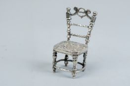 A miniature chair - a miniature silver chair with cherubic decoration, 0.4 ozs, import marks
