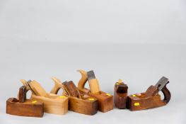 Four wooden smoothing planes including one with steel sole and two wooden toothing planes, various