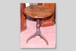 An early oak circular topped tripod table with turned column support and splayed legs, 21 ins (53.