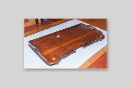 An early 20th Century mahogany folding bed tray with twin carrying handles and central adjustable