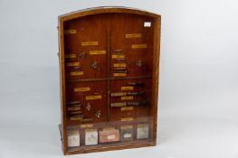 An oak ironmonger's counter top Rawlplug display cabinet with single door glazed display front and