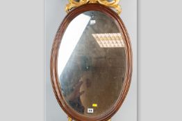 A reproduction mahogany and gilt decorated oval wall mirror, 36 x 18.5 ins (91.5 x 47 cms)