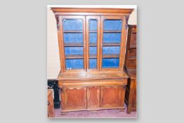 A Victorian oak and mahogany 2.5 door bookcase sideboard, a shaped top over twin arch glazed doors