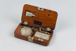 A wooden cased set of travelling scales, the lid of the weights recess bearing the names 'Bauer
