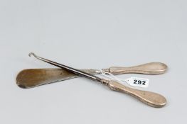 A long silver handled shoe horn and hook pair