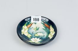 A Moorcroft dish decorated in the 'Lamia' pattern, impressed and painted marks to the base and the