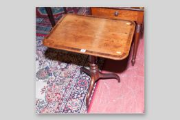 A Georgian mahogany tilt-top tripod table with rosewood crossbanded top and turned column support,