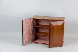 A mahogany two door collector's cabinet with twin chamfered doors and brass pull drop handles,