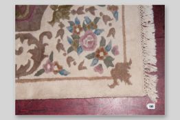 An Indian woollen cream ground and patterned tassel edged carpet, 147 x 108 ins (373.5 x 274 cms)