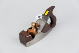 A coffin shaped steel smoothing plane with mahogany infill and handle with bronze clamp, 9.5 ins (24