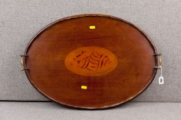An Edwardian mahogany twin handled serving tray, the large Sheraton style shell inlaid centre