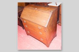 An early 20th Century three drawer fall front mahogany bureau with pierced brass drawer back
