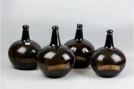 A set of four late 18th/early 19th Century glass apothecary bottles, the dark olive green bottles