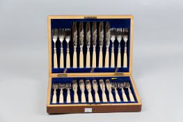 A mahogany cased set of twelve fish knives and forks, all having bright cut decorated blades, leaf