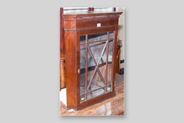 A mahogany single glazed door hanging corner cupboard with ivory escutcheon and single shelf