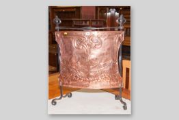 A wrought iron and copper Art Nouveau firescreen with raised stylized floral pattern, 30 x 25 ins (