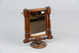 A mahogany turned and block supported gentleman's dressing mirror with metamorphic action for