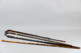 Four decorative wooden walking canes, a rosewood example, two with yellow metal collars, the other