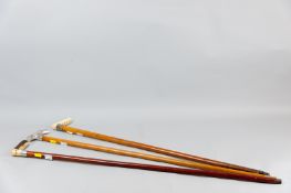 Three walking canes, various wood shafts, one a swordstick with white metal collar and horn