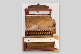 A gilt bronze American National cash register with all over relief floral decoration, twenty seven