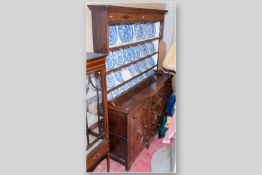 A 19th Century Anglesey oak breakfront dresser with mahogany inlaid diamond frieze, painted back