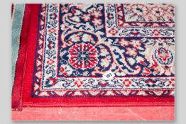 A Middle Eastern red ground patterned woollen carpet, 113 x 78 ins (287 x 199 cms)