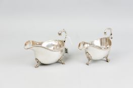 An electroplated sauce boat with feather edge rim, scrolled handle and three shell and claw supports